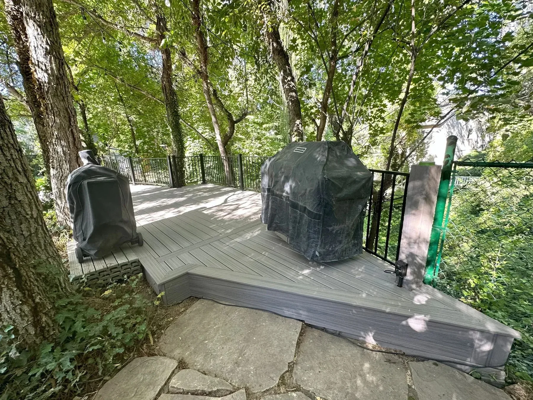 Covered deck area with grill and railing